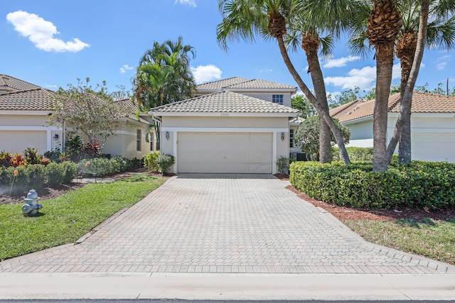 2502 NW 66th Dr, Boca Raton, FL 33496 - view of front of house with stucco siding, an attached garage, a tile roof, and decorative driveway
