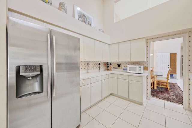 2502 NW 66th Dr, Boca Raton, FL 33496 - kitchen featuring stainless steel refrigerator with ice dispenser, light countertops, light tile patterned floors, decorative backsplash, and white microwave