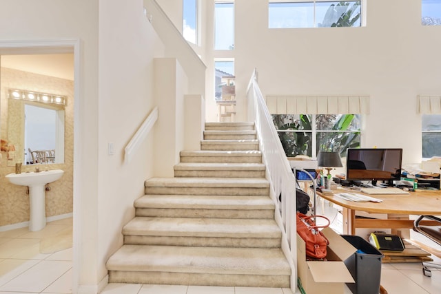 2502 NW 66th Dr, Boca Raton, FL 33496 - staircase with tile patterned floors, a high ceiling, and baseboards