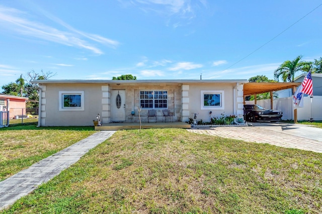 ranch-style home featuring stucco siding, fence, concrete driveway, a front yard, and an attached carport
