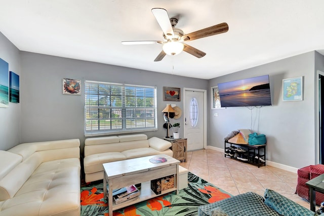 living room featuring light tile patterned floors, baseboards, and ceiling fan