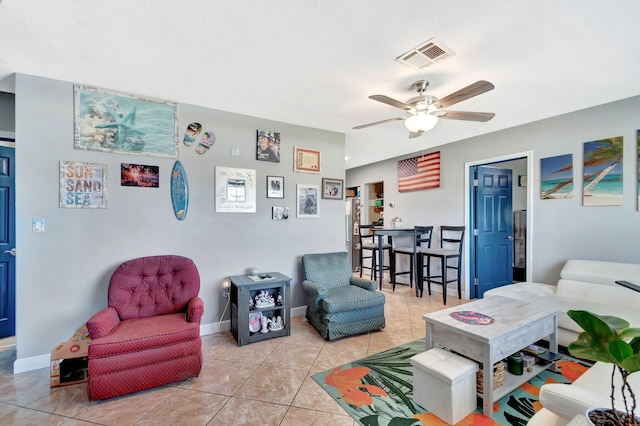 living area featuring light tile patterned floors, baseboards, visible vents, and ceiling fan