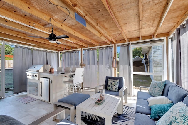sunroom / solarium featuring ceiling fan, outdoor dining area, an outdoor hangout area, and exterior kitchen