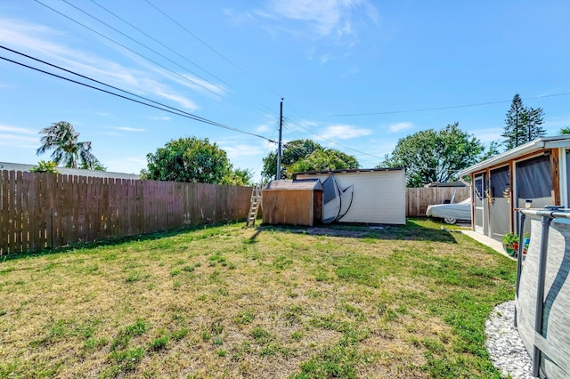 view of yard featuring an outdoor structure, a fenced backyard, and a shed