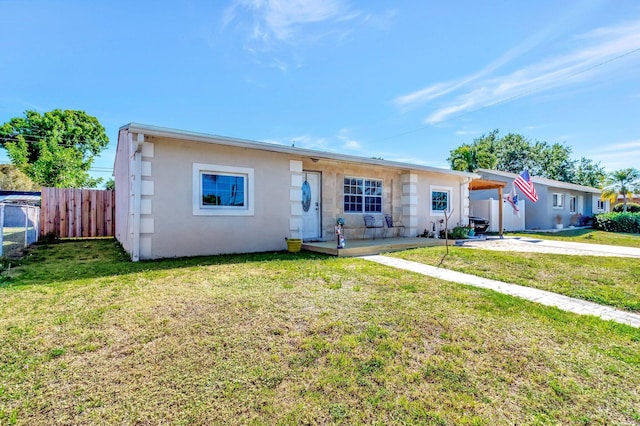ranch-style house featuring stucco siding, fence, concrete driveway, a front yard, and an attached carport