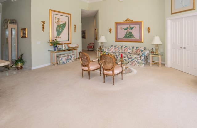 living area featuring carpet flooring, baseboards, and ornamental molding