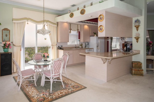 kitchen with a peninsula, a sink, light colored carpet, white refrigerator with ice dispenser, and crown molding