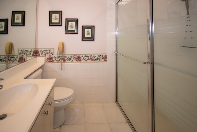 bathroom with toilet, vanity, a wainscoted wall, and a stall shower