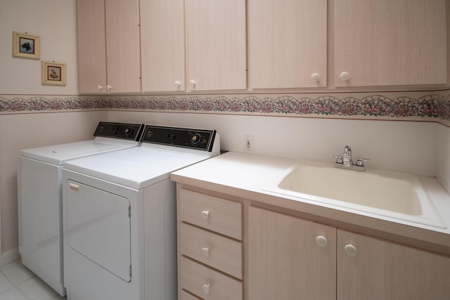 clothes washing area featuring a sink, independent washer and dryer, and cabinet space