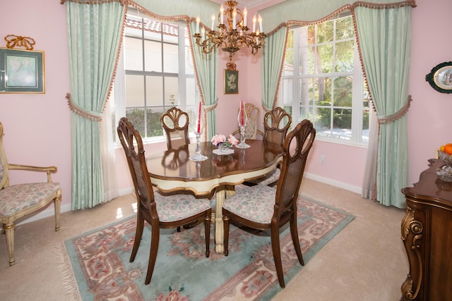 carpeted dining area featuring baseboards and a notable chandelier