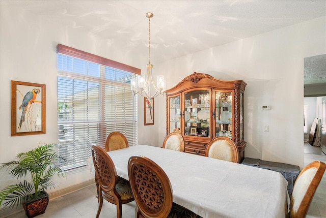5879 NW Leah Dr, Port Saint Lucie, FL 34986 - dining room featuring a chandelier, tile patterned flooring, and baseboards