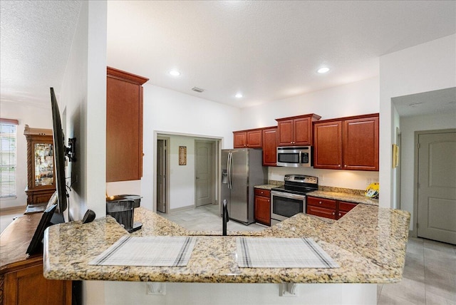 5879 NW Leah Dr, Port Saint Lucie, FL 34986 - kitchen featuring stainless steel appliances, a peninsula, light stone countertops, recessed lighting, and a sink