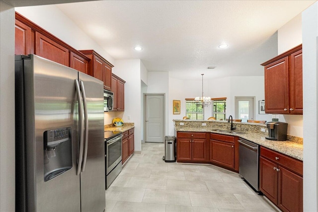 5879 NW Leah Dr, Port Saint Lucie, FL 34986 - kitchen featuring stainless steel appliances, a sink, a peninsula, a chandelier, and light stone countertops