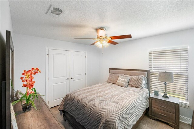5879 NW Leah Dr, Port Saint Lucie, FL 34986 - bedroom featuring light wood-style floors, a closet, a ceiling fan, and a textured ceiling