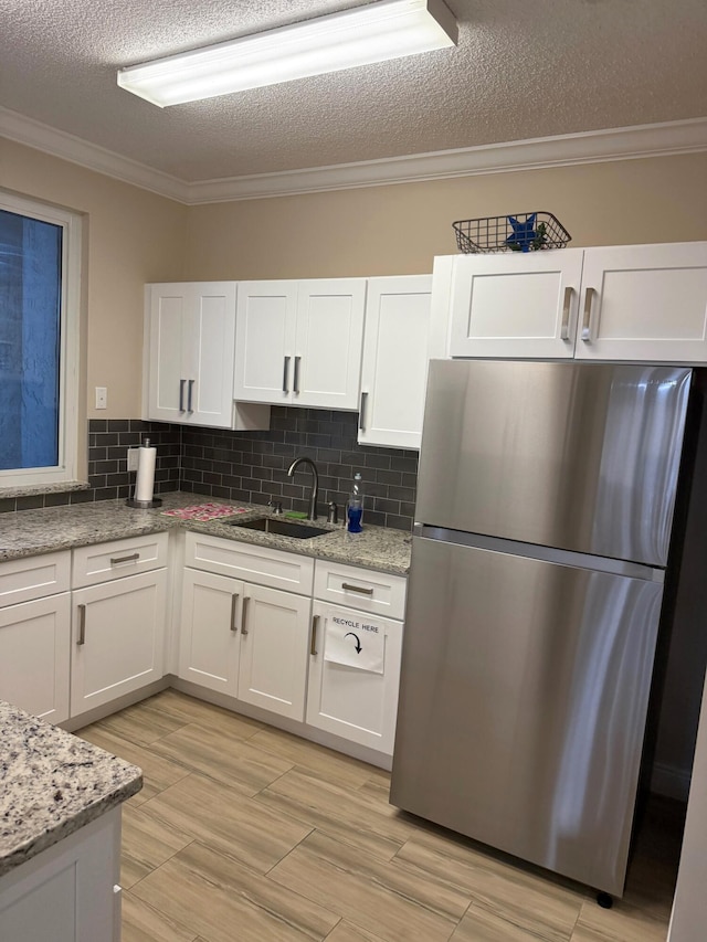 6308 Crystal View Ln, Boynton Beach, FL 33437 - kitchen featuring a sink, freestanding refrigerator, white cabinetry, and a textured ceiling