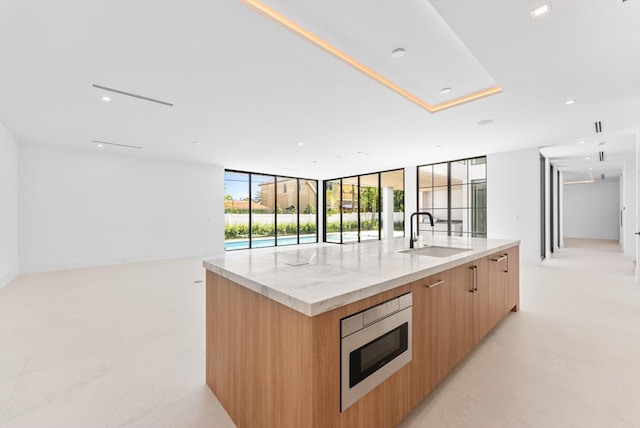 880 NE 3rd Ave, Boca Raton, FL 33432 - kitchen with a sink, modern cabinets, stainless steel microwave, open floor plan, and a large island with sink