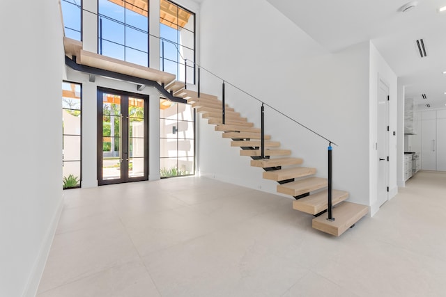 880 NE 3rd Ave, Boca Raton, FL 33432 - stairway featuring baseboards, french doors, and a high ceiling