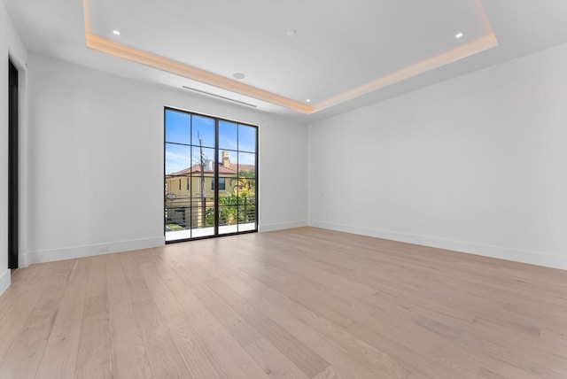 880 NE 3rd Ave, Boca Raton, FL 33432 - unfurnished room with a tray ceiling, light wood-style floors, recessed lighting, and baseboards