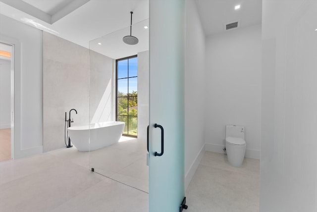 880 NE 3rd Ave, Boca Raton, FL 33432 - bathroom with a freestanding bath, toilet, recessed lighting, tile patterned flooring, and baseboards