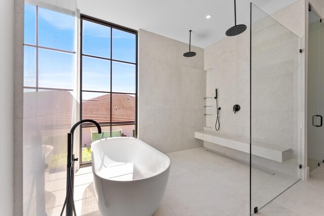880 NE 3rd Ave, Boca Raton, FL 33432 - bathroom with a tile shower, a freestanding bath, tile patterned flooring, and tile walls