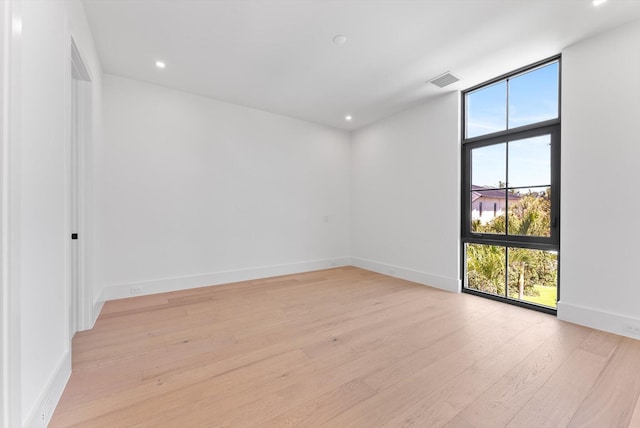 880 NE 3rd Ave, Boca Raton, FL 33432 - spare room featuring plenty of natural light, light wood-type flooring, a wall of windows, baseboards, and recessed lighting