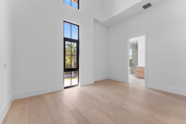 880 NE 3rd Ave, Boca Raton, FL 33432 - unfurnished room with wood finished floors, a towering ceiling, and baseboards