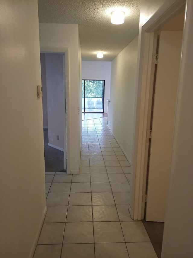 2231 NW 34th Ter, Coconut Creek, FL 33066 - corridor featuring light tile patterned floors, baseboards, and a textured ceiling