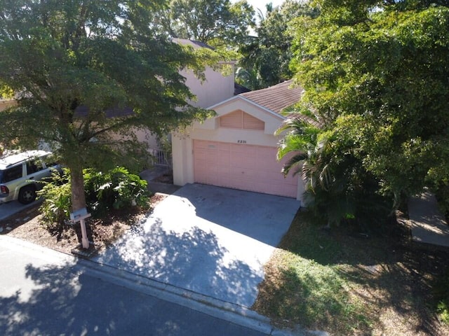 2231 NW 34th Ter, Coconut Creek, FL 33066 - view of front of property with concrete driveway, a tiled roof, a garage, and stucco siding