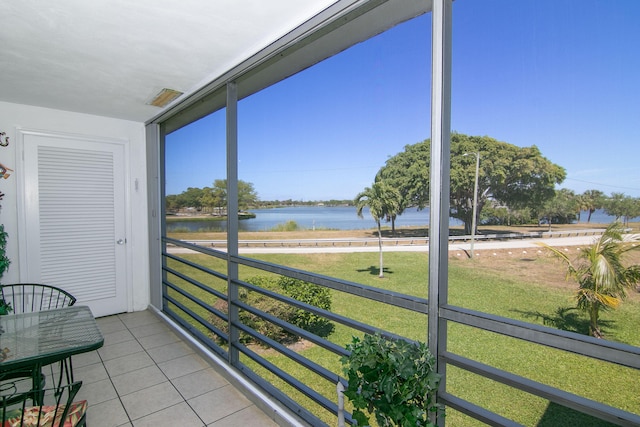 sunroom featuring a water view and a healthy amount of sunlight