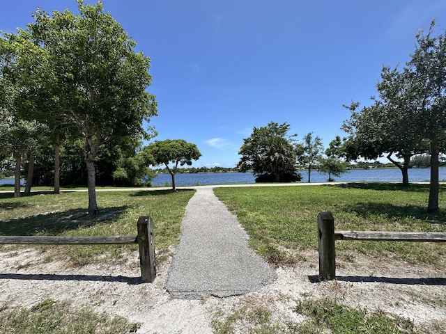 view of property's community with a water view and a yard