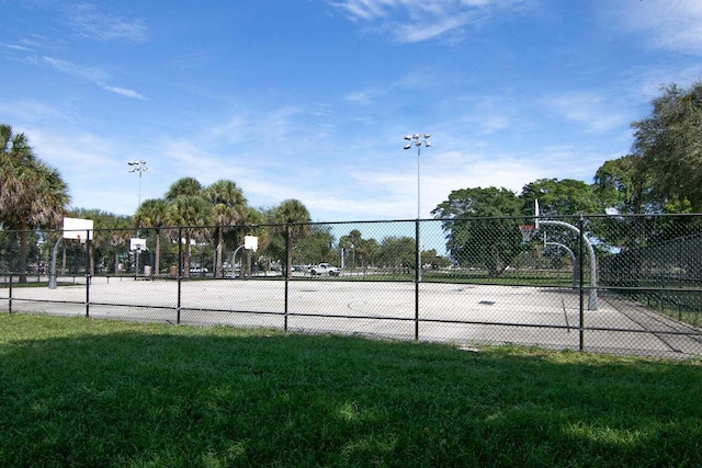 view of sport court featuring a lawn, community basketball court, and fence