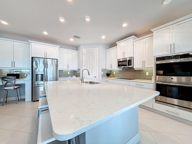 kitchen featuring a sink, visible vents, appliances with stainless steel finishes, and light tile patterned flooring