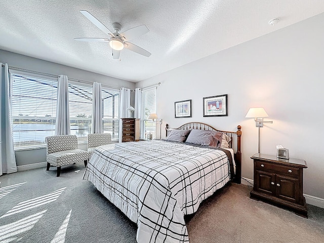 carpeted bedroom featuring a ceiling fan, baseboards, and a textured ceiling