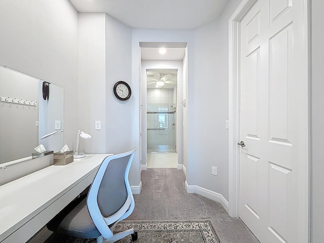 carpeted home office featuring baseboards and ceiling fan