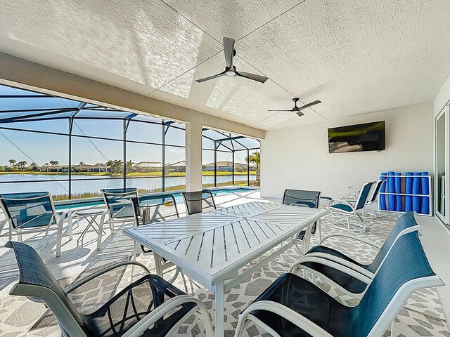 view of patio with a swimming pool, glass enclosure, outdoor dining area, and a ceiling fan