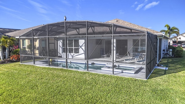back of house with a lanai, roof with shingles, a lawn, a patio area, and an outdoor pool