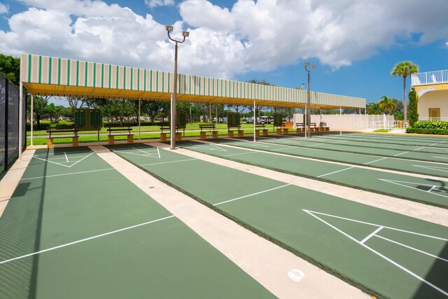 view of community featuring shuffleboard and fence