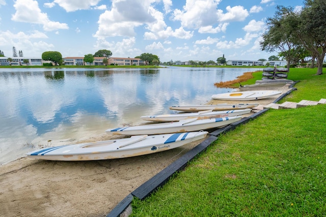 view of dock with a yard and a water view