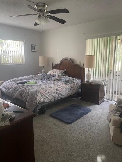 carpeted bedroom featuring a textured ceiling, ceiling fan, and access to outside