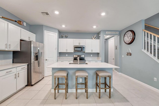 1012 Willow Pl, Riviera Beach, FL 33410 - kitchen featuring appliances with stainless steel finishes, a sink, a kitchen breakfast bar, light countertops, and white cabinets