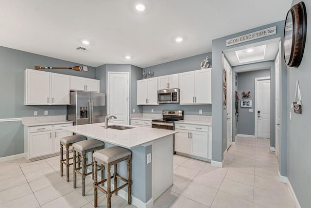 1012 Willow Pl, Riviera Beach, FL 33410 - kitchen with appliances with stainless steel finishes, a sink, a breakfast bar area, white cabinetry, and recessed lighting