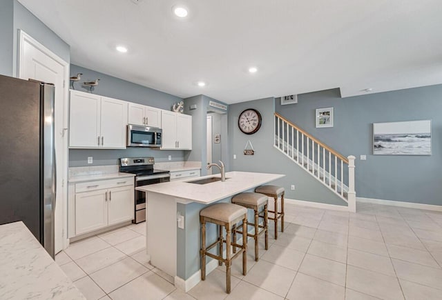 1012 Willow Pl, Riviera Beach, FL 33410 - kitchen with appliances with stainless steel finishes, a sink, white cabinetry, a kitchen breakfast bar, and recessed lighting