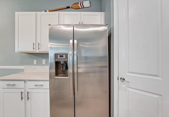 1012 Willow Pl, Riviera Beach, FL 33410 - kitchen with stainless steel fridge, white cabinets, and light stone countertops
