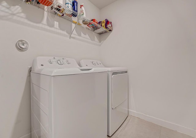 1012 Willow Pl, Riviera Beach, FL 33410 - clothes washing area with washing machine and clothes dryer, baseboards, and light tile patterned flooring