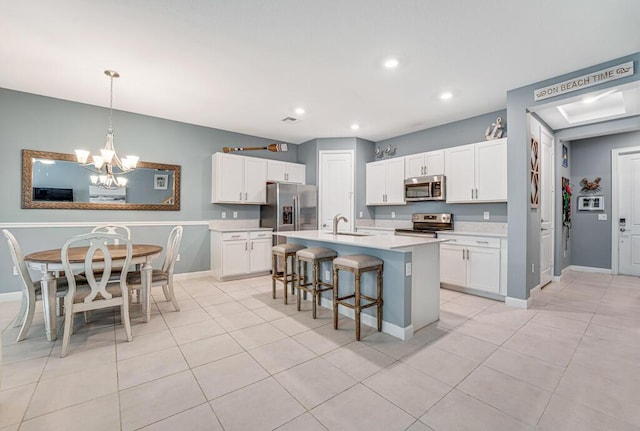 1012 Willow Pl, Riviera Beach, FL 33410 - kitchen with stainless steel appliances, a sink, a kitchen breakfast bar, light countertops, and a chandelier