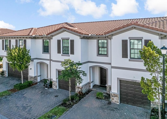 1012 Willow Pl, Riviera Beach, FL 33410 - view of front of home featuring an attached garage, stone siding, stucco siding, and decorative driveway