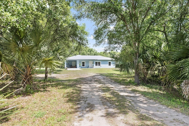 7633 NW 93rd Ct, Okeechobee, FL 34972 - view of front facade featuring driveway, stucco siding, and metal roof