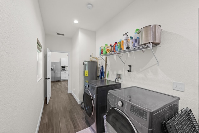 7633 NW 93rd Ct, Okeechobee, FL 34972 - laundry area with visible vents, baseboards, wood finished floors, water heater, and washer and clothes dryer