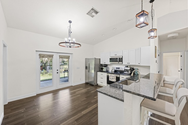 7633 NW 93rd Ct, Okeechobee, FL 34972 - kitchen with a sink, dark stone countertops, stainless steel appliances, visible vents, and white cabinets