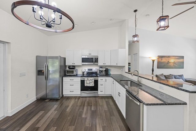 7633 NW 93rd Ct, Okeechobee, FL 34972 - kitchen with white cabinets, dark stone counters, appliances with stainless steel finishes, dark wood-type flooring, and a sink